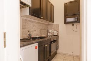 a kitchen with brown cabinets and a sink at Peerles 2BR Apt. Perfectly Situated&Well Connected in Vienna