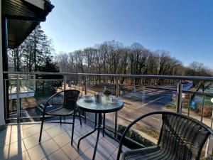 balcón con mesa y sillas y vistas a la calle en Villa Cristal en Świnoujście