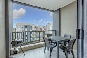 a balcony with a table and chairs and a window at Cosy Butterfly Comforts 2 Bed Top Floor Unit in Fourways