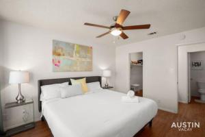 una camera con letto bianco e ventilatore a soffitto di WFH in Relaxing Clarksville Townhome with Parking ad Austin
