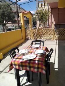 a table with a plaid table cloth on a patio at Serafi Cozy Rooms in Archangelos