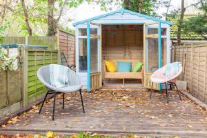 a garden with two chairs and a gazebo at Sunny Beck Cottage - Norfolk Cottage Agency in Mundesley