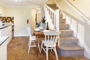 una cucina e una sala da pranzo con tavolo e sedie di Sunny Beck Cottage - Norfolk Cottage Agency a Mundesley