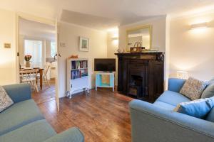 a living room with a couch and a fireplace at Sunny Beck Cottage - Norfolk Cottage Agency in Mundesley