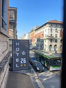 un autobús conduciendo por una calle de la ciudad con coches en Hotel 26, en Milán