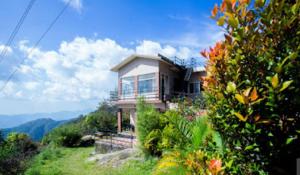 uma casa ao lado de uma colina com flores em Alcyone Valley Panchalimedu em Pīrmed