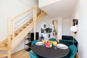 a living room with a table and chairs and a staircase at Snow YourHostHelper in Cannes
