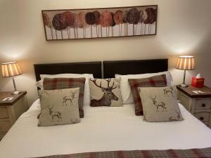 a bed with white sheets and pillows with deer pillows at The Shoulder of Mutton in Bradwell