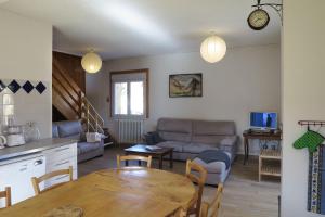 a living room with a table and a couch at Gîte SOLDANELLE - 15 personnes - "Les Gites du Chalet" à Autrans in Autrans