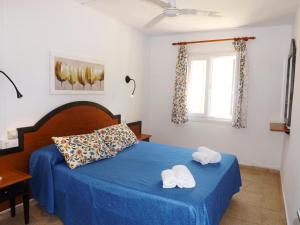 a bedroom with a blue bed with two towels on it at Nure Cel Blau in Cala'n Bosch