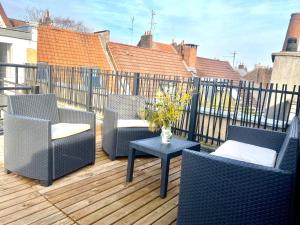 eine Terrasse mit Stühlen und einem Tisch auf einer Terrasse in der Unterkunft Appartement Léonard, comme à la maison - Vieux Lille in Lille