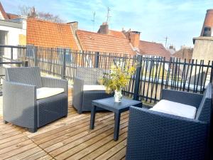 um pátio com cadeiras e uma mesa num deque em Appartement Léonard, comme à la maison - Vieux Lille em Lille