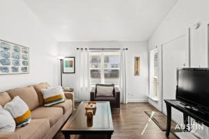 a living room with a couch and a tv at 5 Minutes to Zilker Barton Springs with Parking in Austin