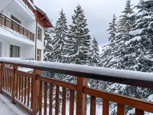 een balkon van een huis met sneeuw bedekte bomen bij Semiramida gardens Apartment 23 in Borovets