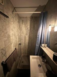 uma casa de banho com uma banheira, um lavatório e um chuveiro em Superbe studio avec piscine ext em Antibes