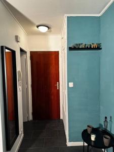 um corredor com uma porta vermelha e uma parede azul em Superbe studio avec piscine ext em Antibes