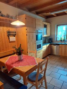 a kitchen with a wooden table and a table and chairs at Ferienwohnung Hasenfratz in Löffingen