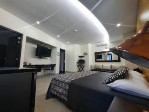 a bedroom with a bed and a flat screen tv at Hotel Mediterraneo in Medellín