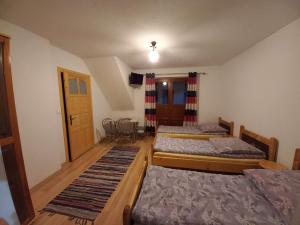 Łapszanka的住宿－Noclegi u Celiny i józefa，一间卧室配有三张床和一张桌子及椅子
