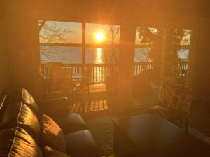 a living room with the sun setting through a window at 2 BR Newly Renovated Waterfront Home; 10 min from MGM & the Gaylord in Fort Washington