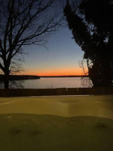 a view of a body of water with the sunset at 2 BR Newly Renovated Waterfront Home; 10 min from MGM & the Gaylord in Fort Washington