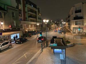una calle de ciudad vacía por la noche con coches aparcados en appartement luxueux 70m2, 2 chambres, en Argenteuil