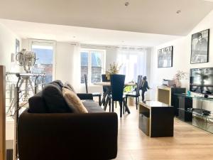 a living room with a couch and a dining room at Appartement Léonard, comme à la maison - Vieux Lille in Lille