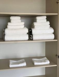 Un paquet de serviettes est empilé sur une étagère dans l'établissement appartement luxueux 70m2, 2 chambres, à Argenteuil
