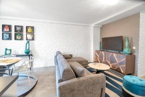 sala de estar con sofá, mesas y TV en Luxury apartment 200 meters from Place des Lices, en Saint-Tropez