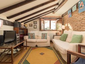 ein Wohnzimmer mit 2 weißen Sofas und einem TV in der Unterkunft Espectacular casa con encanto in Cubas