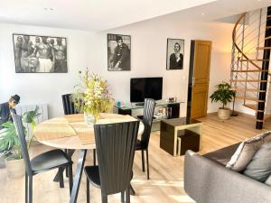 a dining room and living room with a table and chairs at Appartement Léonard, comme à la maison - Vieux Lille in Lille