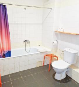 a bathroom with a toilet and a bath tub at Hotel Zimní stadion in Nymburk