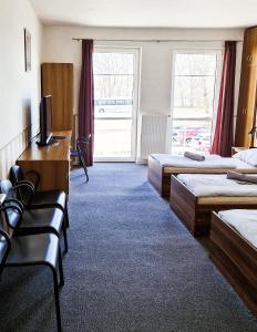 una camera d'albergo con due letti e una televisione di Hotel Zimní stadion a Nymburk