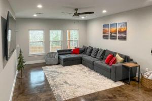uma sala de estar com um sofá cinzento e almofadas vermelhas em Modern Pottsboro Home - Close to Lake Texoma! em Pottsboro
