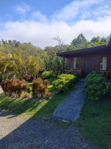 a house with a walkway next to a yard at Belcruz family lodge in Monteverde Costa Rica