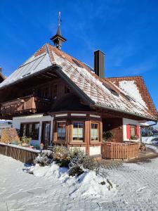 Un bâtiment avec une croix en haut dans la neige dans l'établissement Ferienwohnung Hasenfratz, à Löffingen