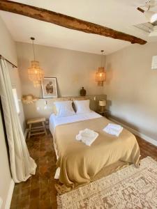 a bedroom with a large bed with two towels on it at MAISON NOMADE Valbonne in Valbonne
