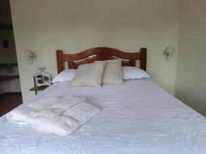 a bed with two towels and two pillows on it at Pousada Azaléia in Rio das Flores