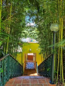 a stairway with a yellow wall and trees at Pousada Azaléia in Rio das Flores