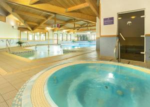a large swimming pool in the middle of a building at Praa Sands Holiday Park in Saint Hilary