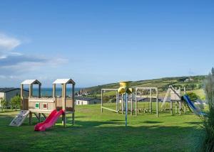 un parque con parque infantil con tobogán y estructura de juegos en Praa Sands Holiday Park, en Saint Hilary