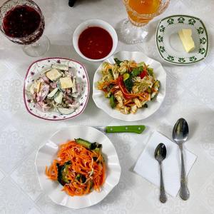 una mesa con tres platos de comida. en Guest House Jekshen, en Imeni Karla Marksa