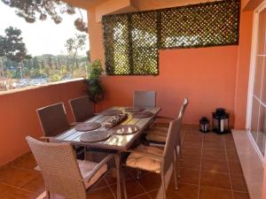 comedor con mesa, sillas y ventana en Elviria Marbella Pinogolf en Marbella