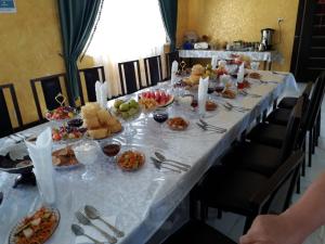 una mesa larga con platos de comida. en Guest House Jekshen en Imeni Karla Marksa