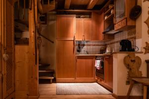 a kitchen with wooden cabinets and a refrigerator at SciliarGuestHouse-due piani parcheggio privato in Castelrotto