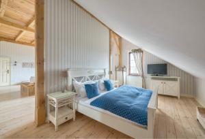 1 dormitorio con 1 cama con edredón azul en Ciekocinko Powozownia en Ciekocinko