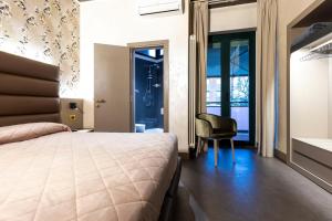 a bedroom with a bed and a chair and a window at Hotel Dei Nani in Iesi