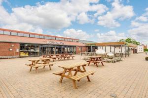 eine Gruppe Picknicktische vor einem Gebäude in der Unterkunft Grange Leisure Park in Mablethorpe