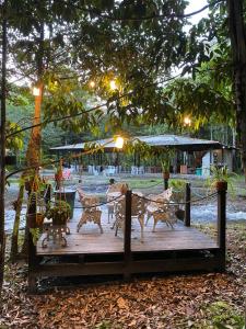 a wooden deck with a table and chairs on it at Pousada Paraíso do Calango Azul in Presidente Figueiredo