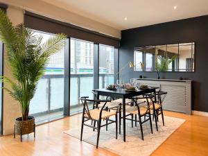 a dining room with a black table and chairs at Lovely 2 Bed Duplex Apartment with Hydro Views in Glasgow